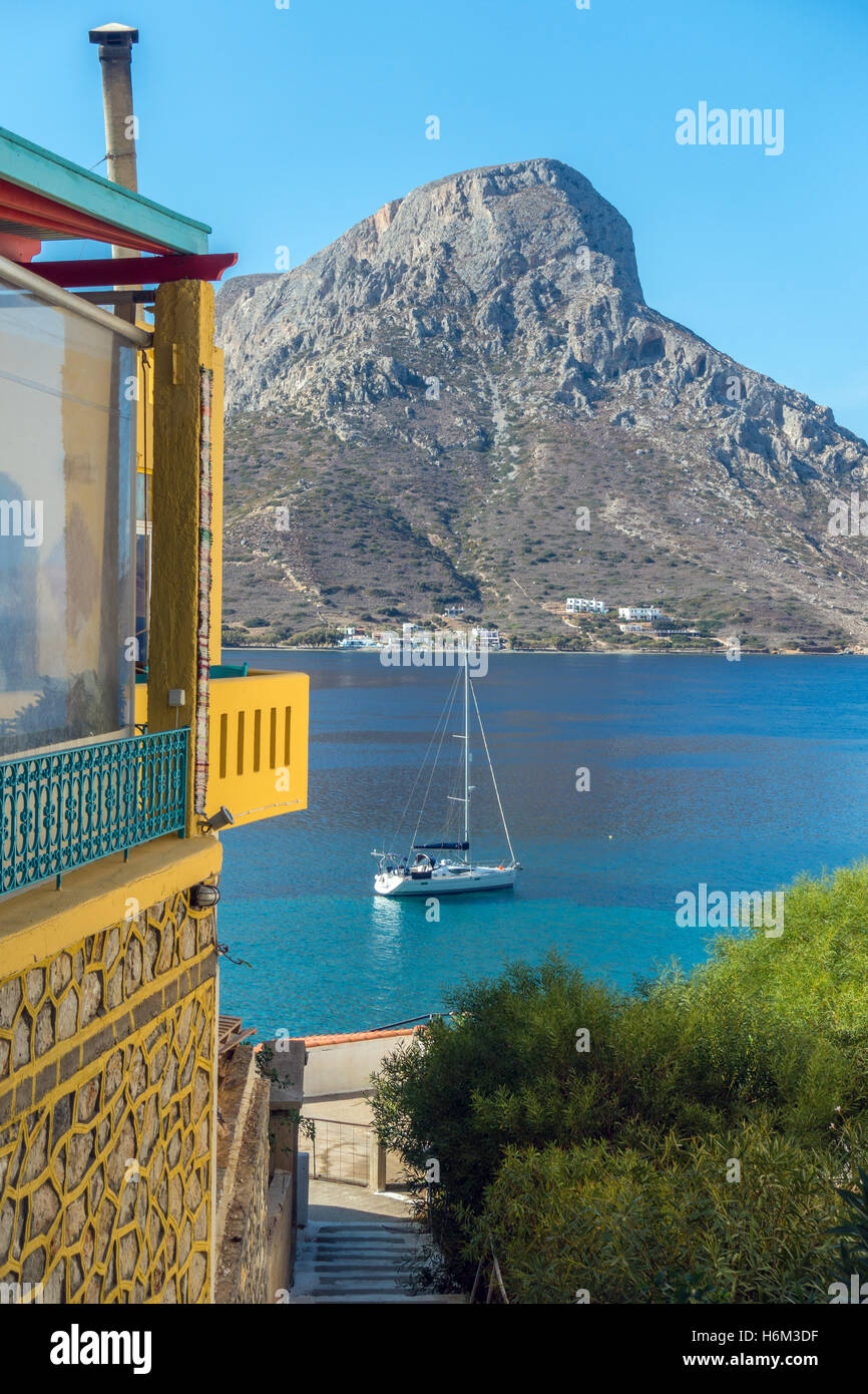 Yacht à voile à la solitaire de Telendos avec Massouri derrière, sur la mer Egée, l'aigue-marine, bleu Banque D'Images
