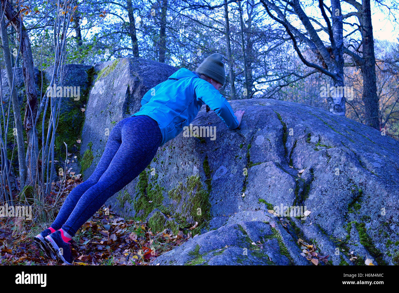Femme de la formation. Faire poussez se lève à l'encontre de big rock. Banque D'Images