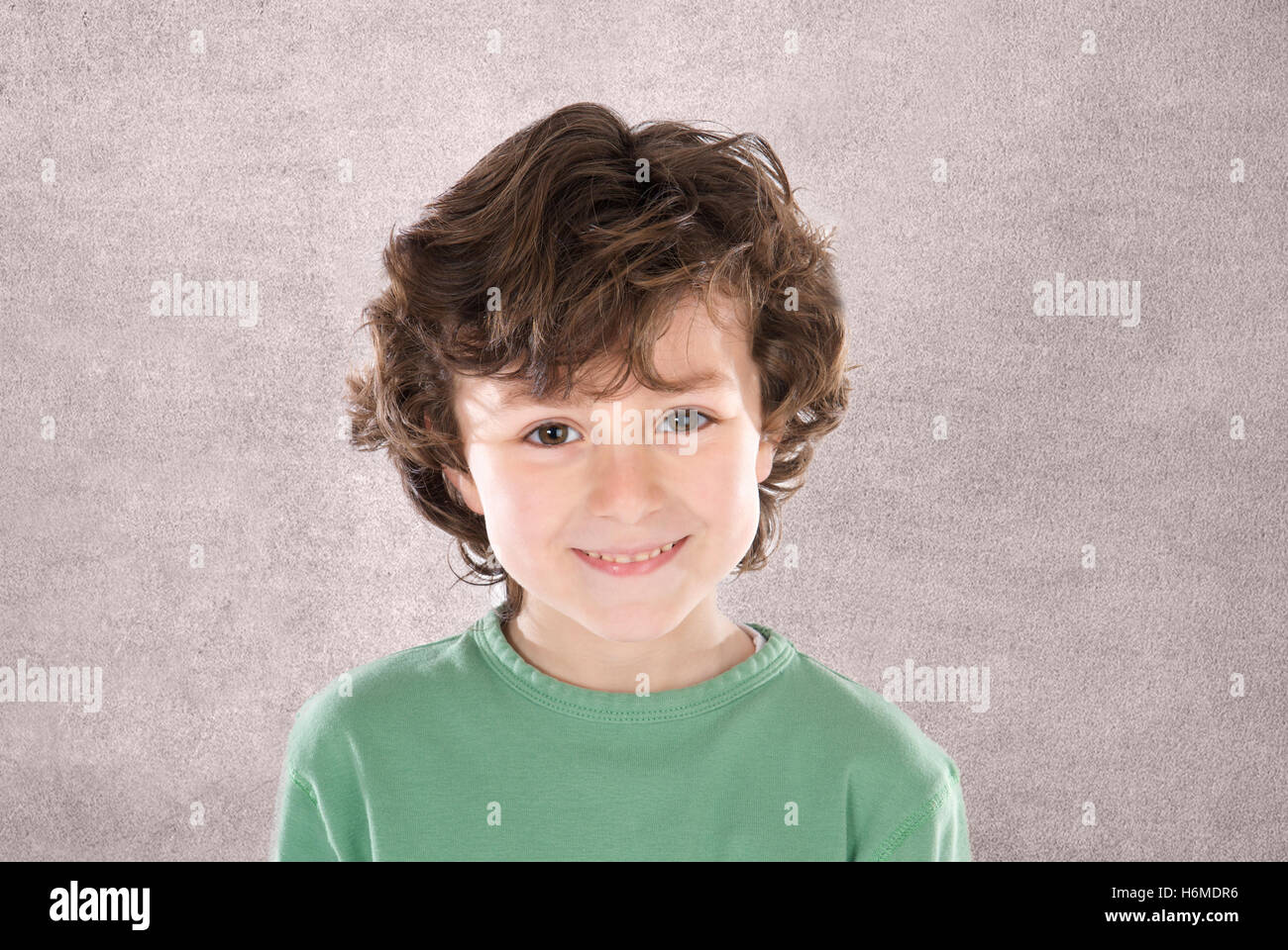 Smiling boy with six ans looking at camera sur fond gris Banque D'Images