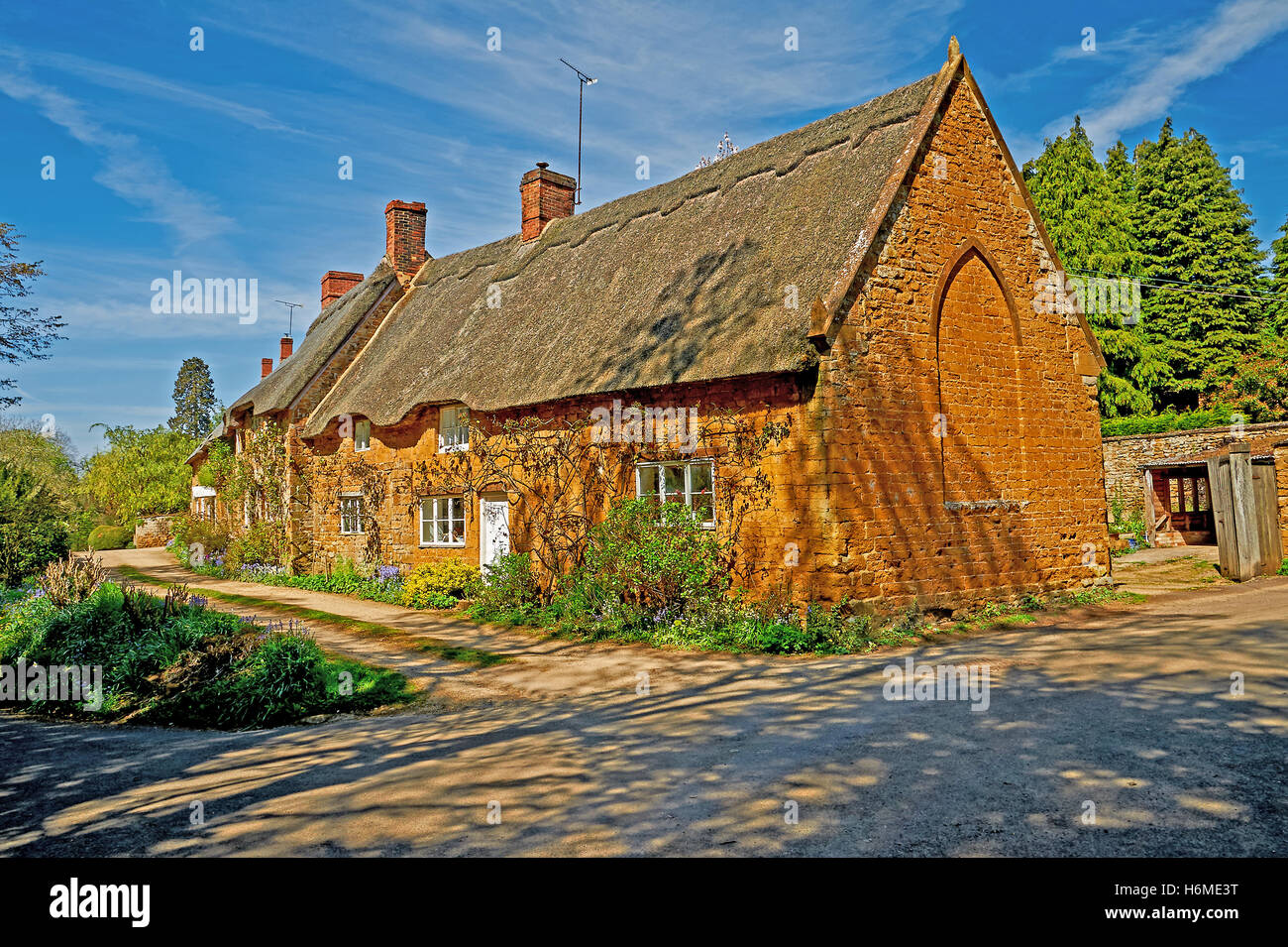 Maison en pierre au toit de chaume et dans le village de Wroxton north Oxfordshire Banque D'Images