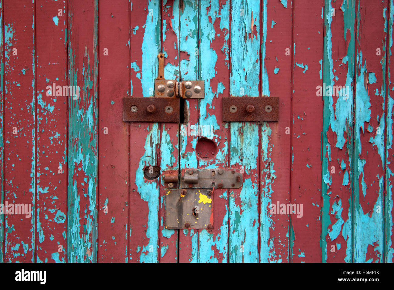 Vieille porte cadenas colorés avec peinture écaillée Banque D'Images