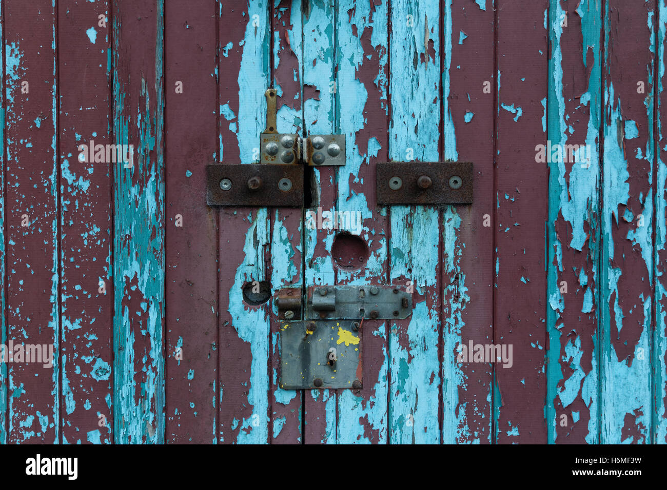 Vieille porte cadenas colorés avec peinture écaillée Banque D'Images