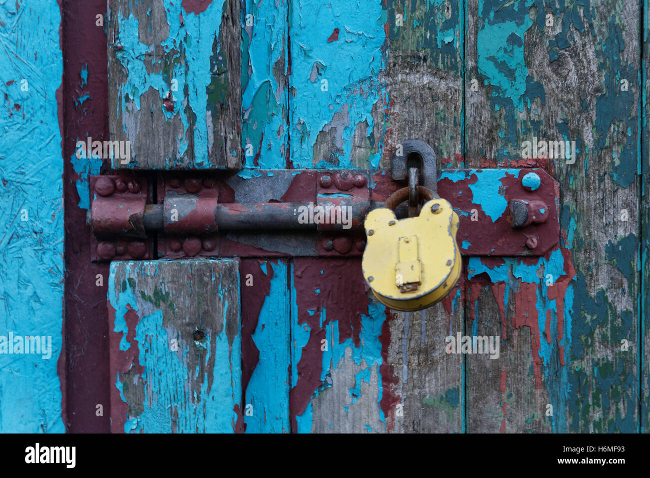 Vieille porte cadenas colorés avec peinture écaillée Banque D'Images