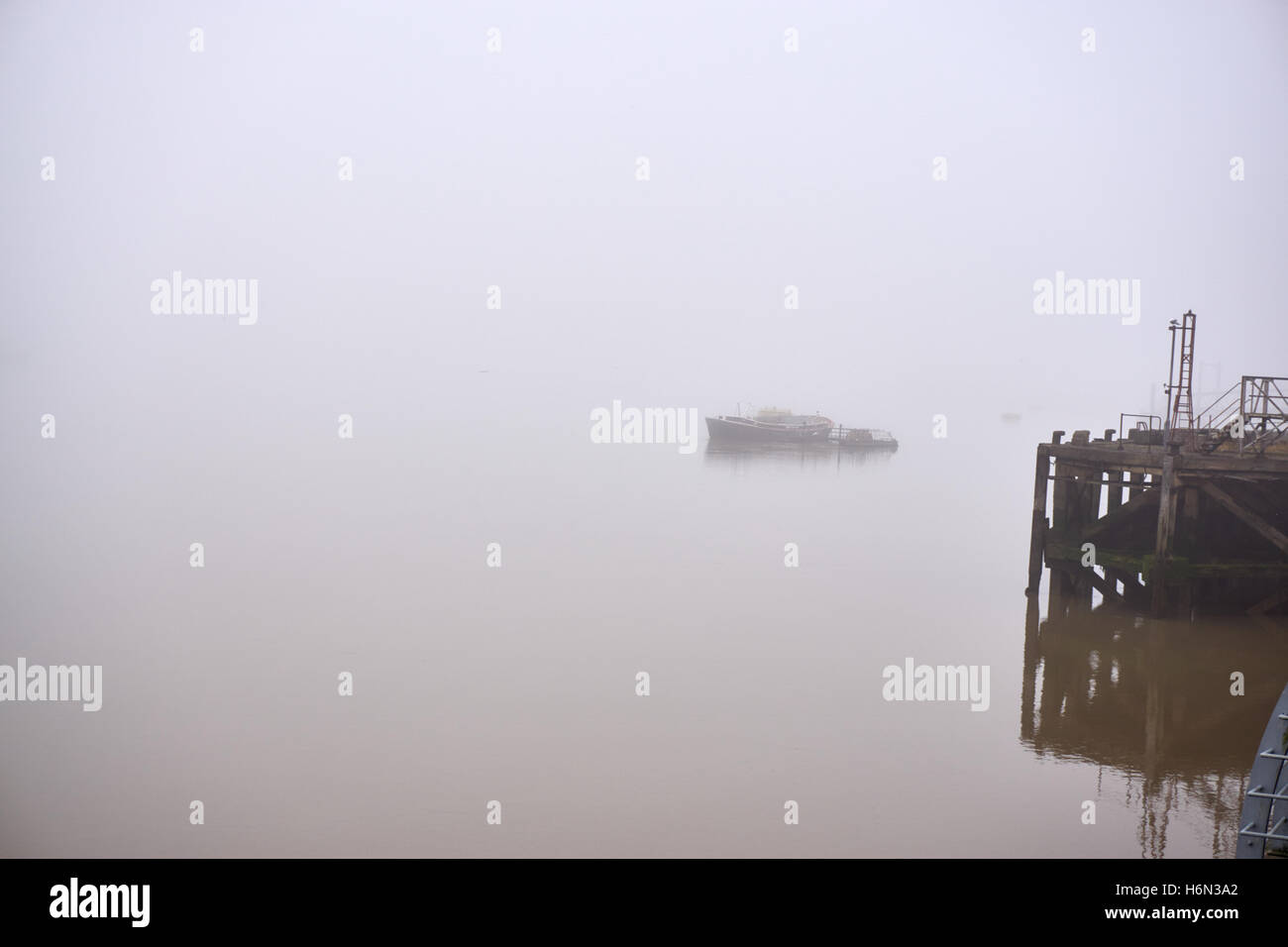 Bateaux fantomatique et de la jetée qui sortent d'épais brouillard d'automne sur la Tamise à Woolwich, Londres Banque D'Images