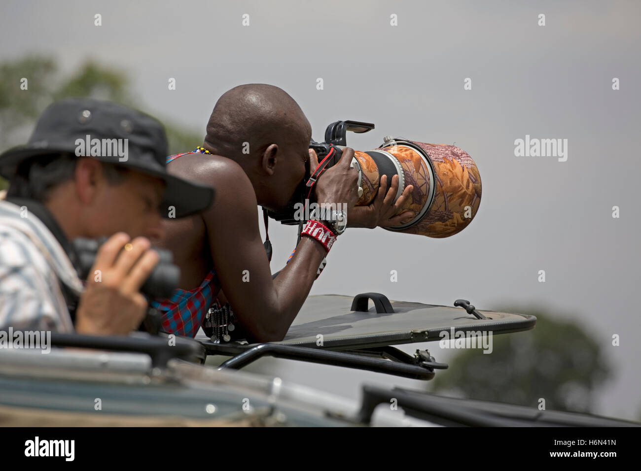 Guide le conducteur à l'aide d'Afrique Masai téléobjectif long Masai Mara, Kenya Banque D'Images