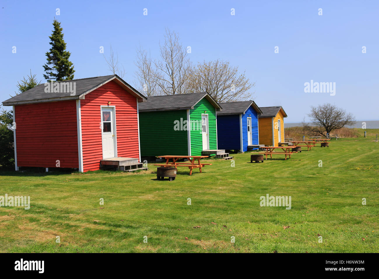 Une chambre colorée ou des cabanes cabines avec des tables de pique-nique et un foyer à feu près de l'océan à St Martins Nouveau-Brunswick, Canada Banque D'Images