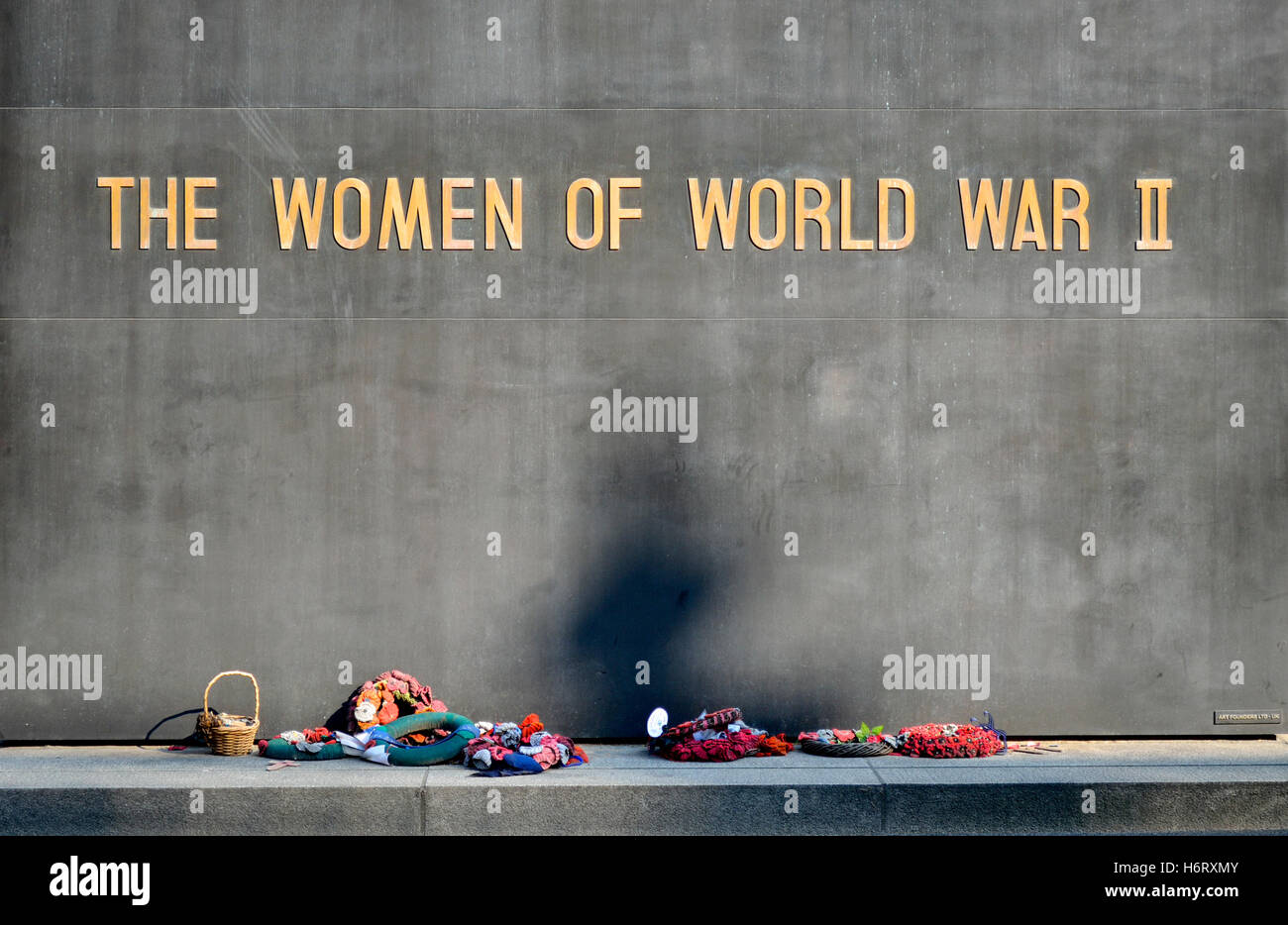 Londres, Angleterre, Royaume-Uni. Les femmes de World War II memorial à Whitehall. Couronnes et un panier de fleurs à gauche Banque D'Images