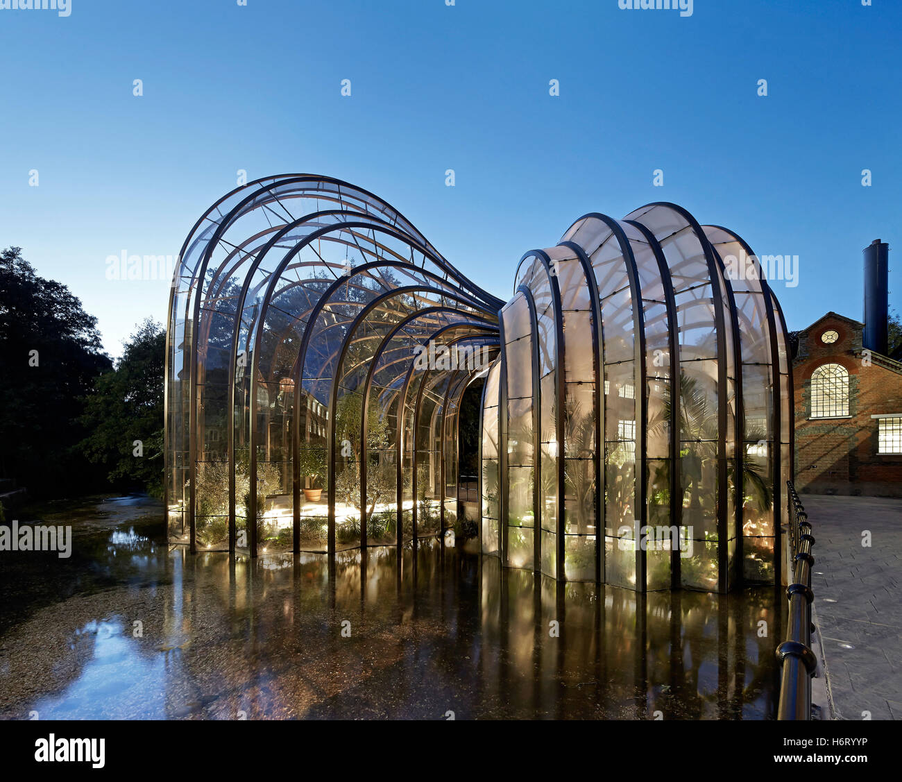 Les serres en courbe de la rivière à côté de l'essai. La Distillerie de Bombay Sapphire, Laverstoke, Royaume-Uni. Architecte : Heatherwick, 2014. Banque D'Images