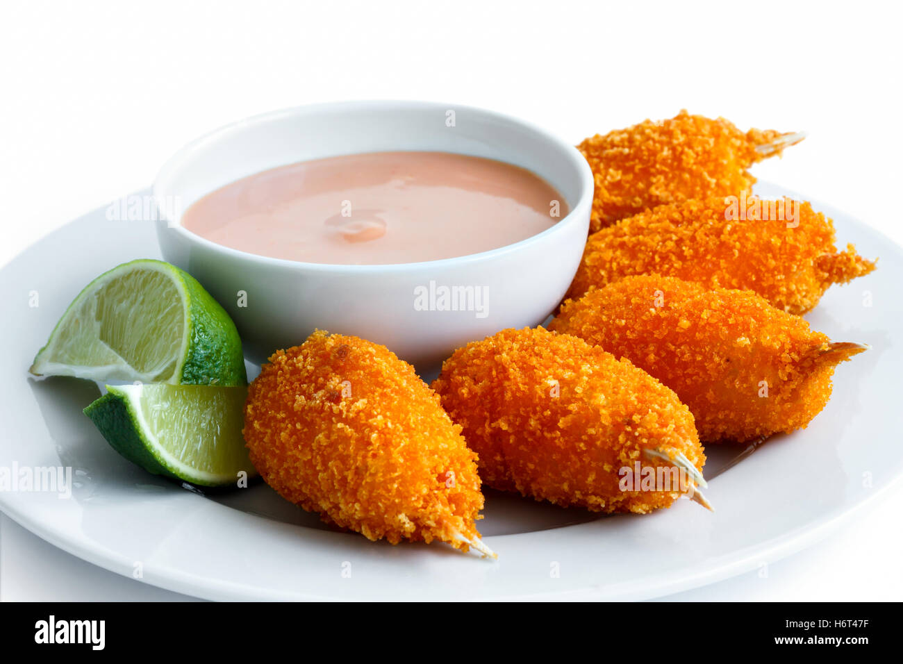 Assiette de pinces de crabe surimi pané frit avec bol de sauce Rose et de tranches de citron isolé sur blanc. Banque D'Images