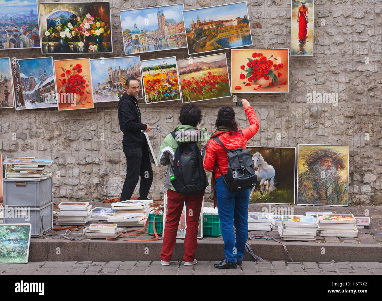 Les touristes non identifiés de prendre des photos d'une galerie de peintures sur le mur près de la Défense St porte Saint-Florian, Cracovie, Pologne Banque D'Images