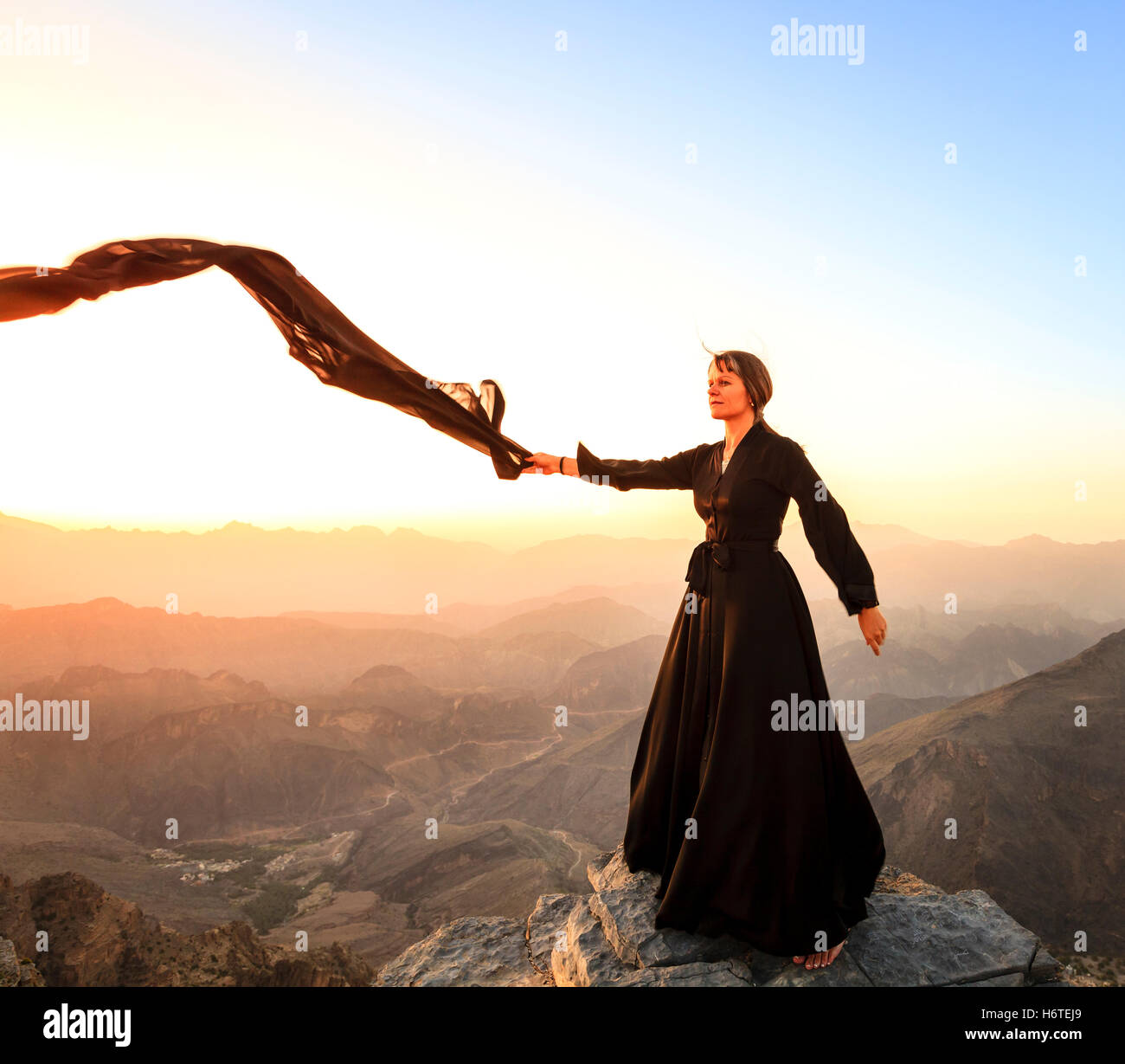 Femme seule en abaya dans Al Hajar Montagnes d'Oman au coucher du soleil Banque D'Images