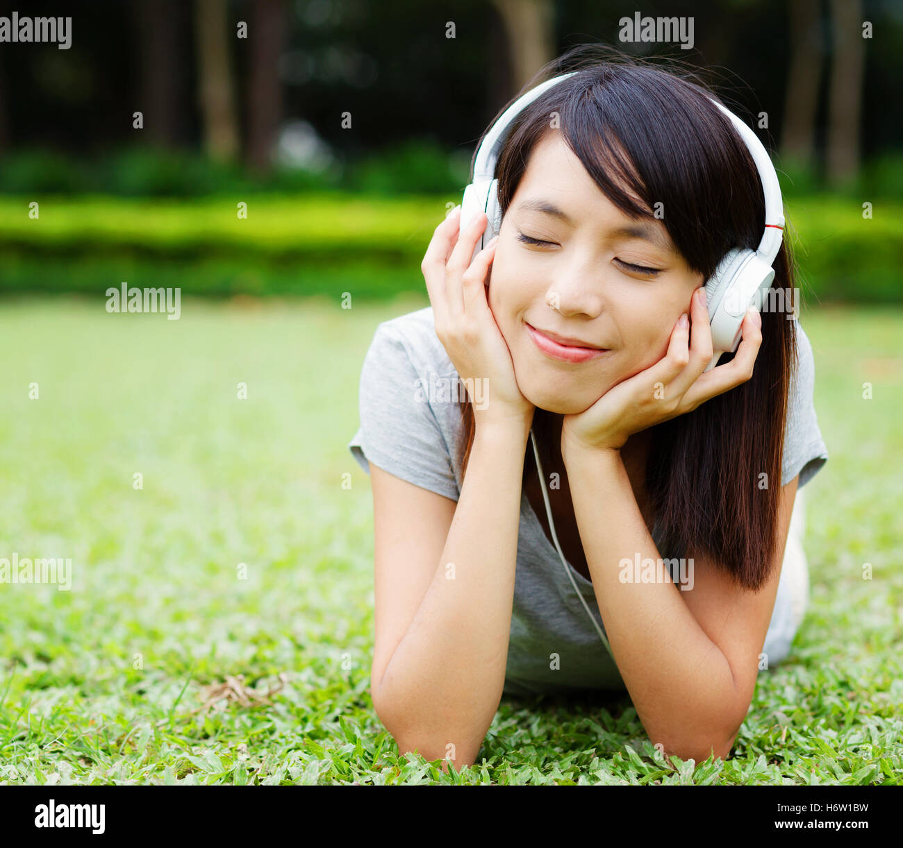 Femme écouter de la musique profitez de mentir mentir se couche asiatique  casque chanson meadow pelouse femme asiatique vert profitez de la musique  de l'écouteur Photo Stock - Alamy
