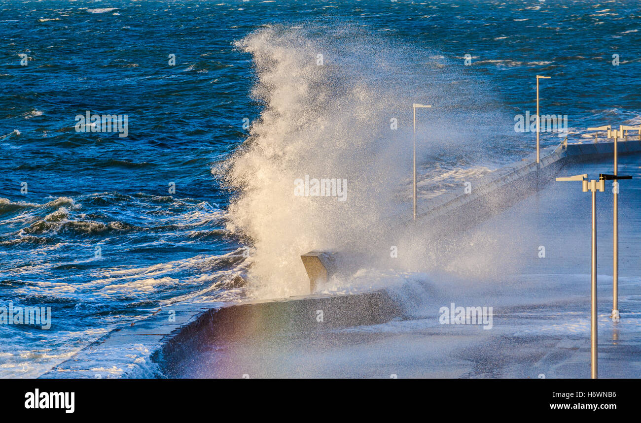 Grande vague de broyage et d'un brise-lames de la jetée de Mornington, créant un arc-en-ciel. Melbourne, Victoria, Australie. Banque D'Images