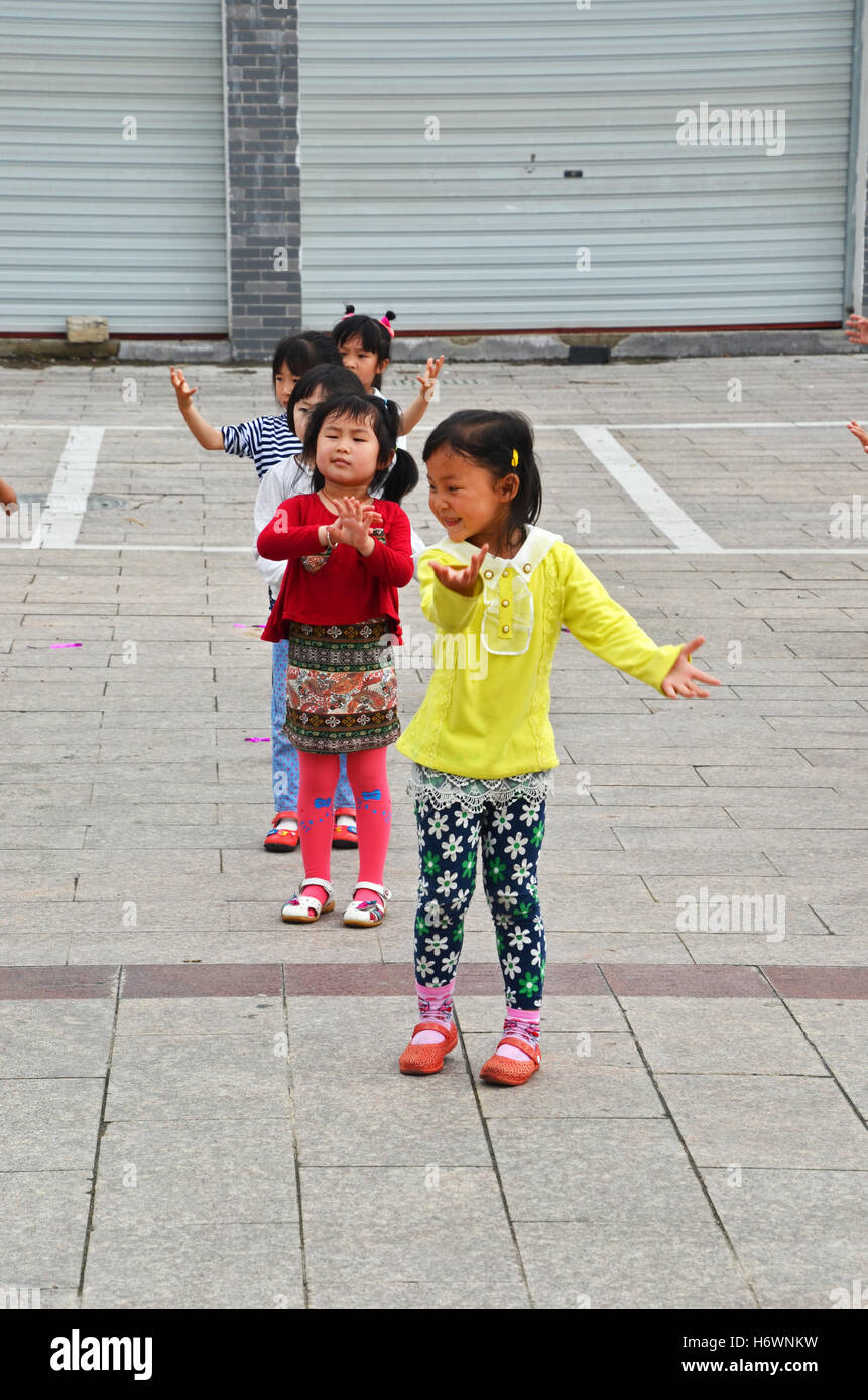 Les écoliers danser ensemble dans une rangée près de Yuliang, village du comté de Shexian, Chine Banque D'Images