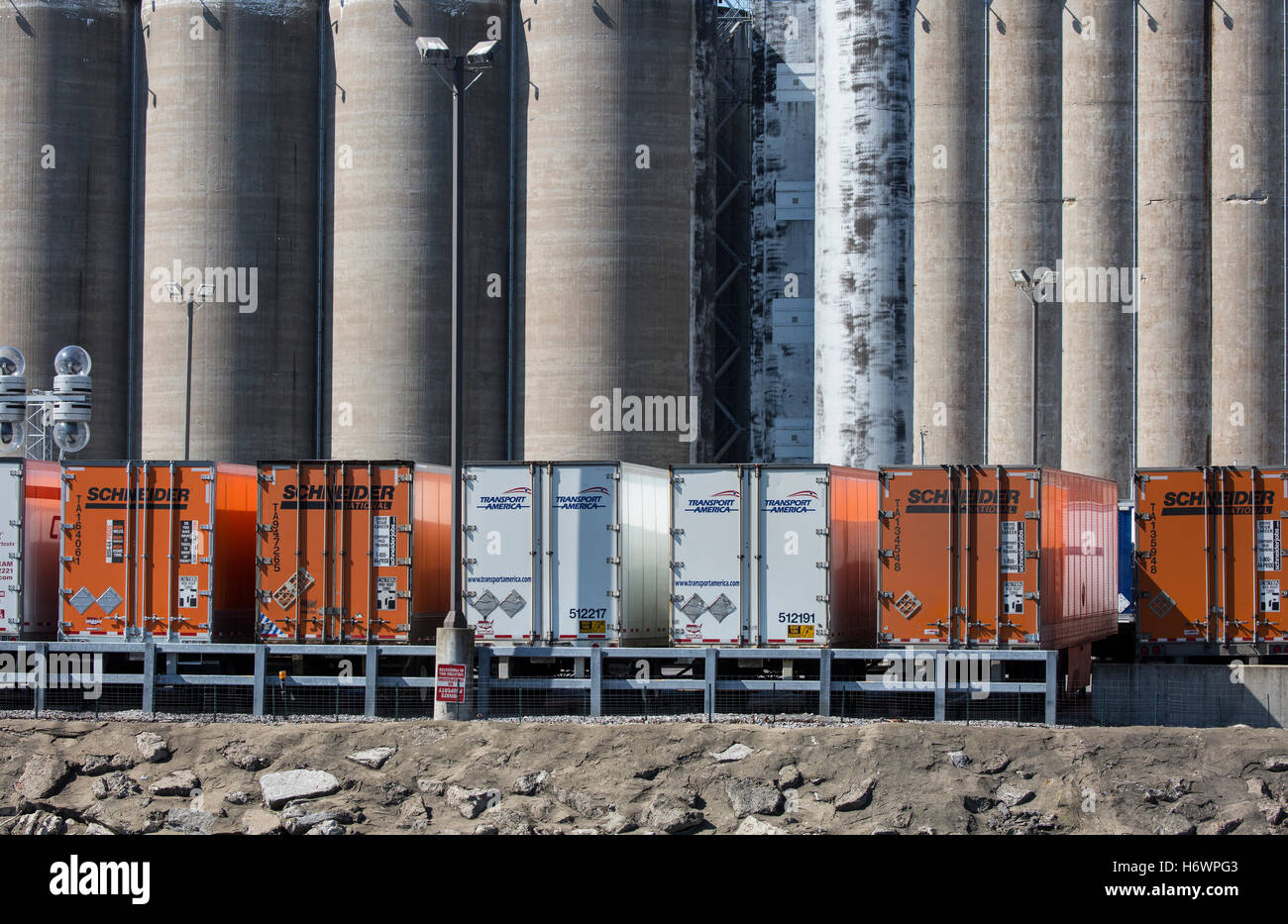 Les silos à grains avec des remorques de camion devant les silos. Banque D'Images