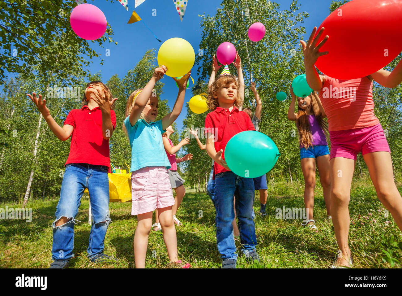Mignon enfants heureux de jouer avec des ballons colorés Banque D'Images