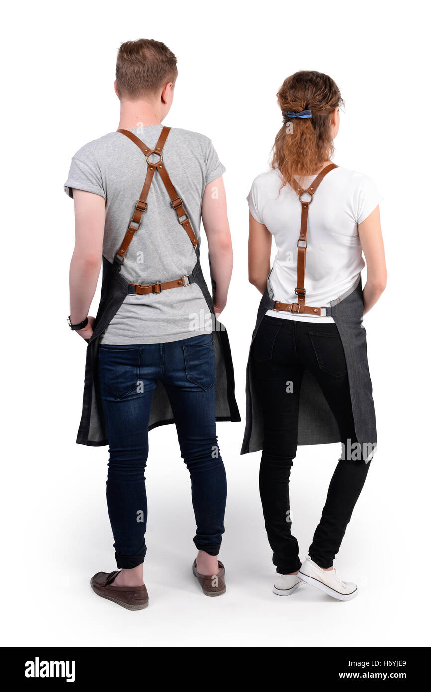 Jeunes chefs ou maîtres d'homme et de la femme pose, portant des tabliers isolé sur fond blanc. Banque D'Images