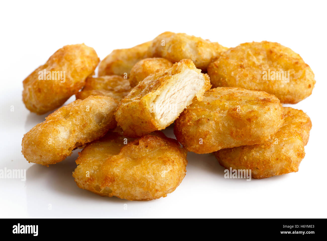 Pile de golden deep-fried chicken nuggets battues isolé sur blanc. Une coupe avec de la viande. Banque D'Images