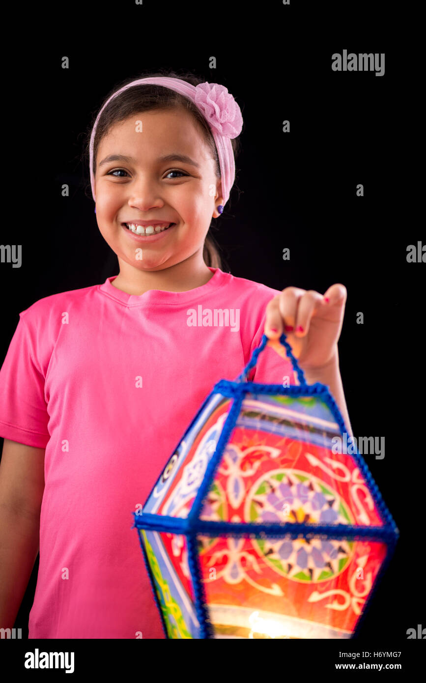 Happy Girl Holding Big Ramadan lanterne sur fond noir Banque D'Images