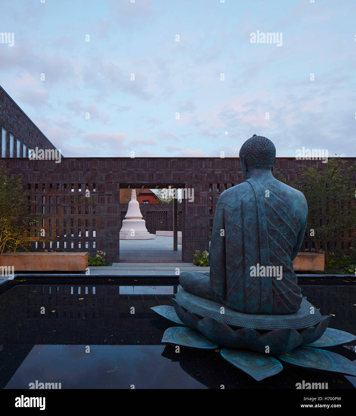 Le lien entre cours avec la figure de Bouddha au crépuscule. Vajrasana Retreat, Westhorpe, Royaume-Uni. Architecte : Walters et Cohen Ltd, 2016. Banque D'Images