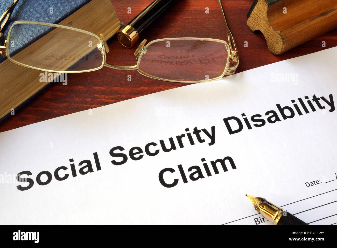 Réclamation d'invalidité de la sécurité sociale sur une table en bois. Banque D'Images