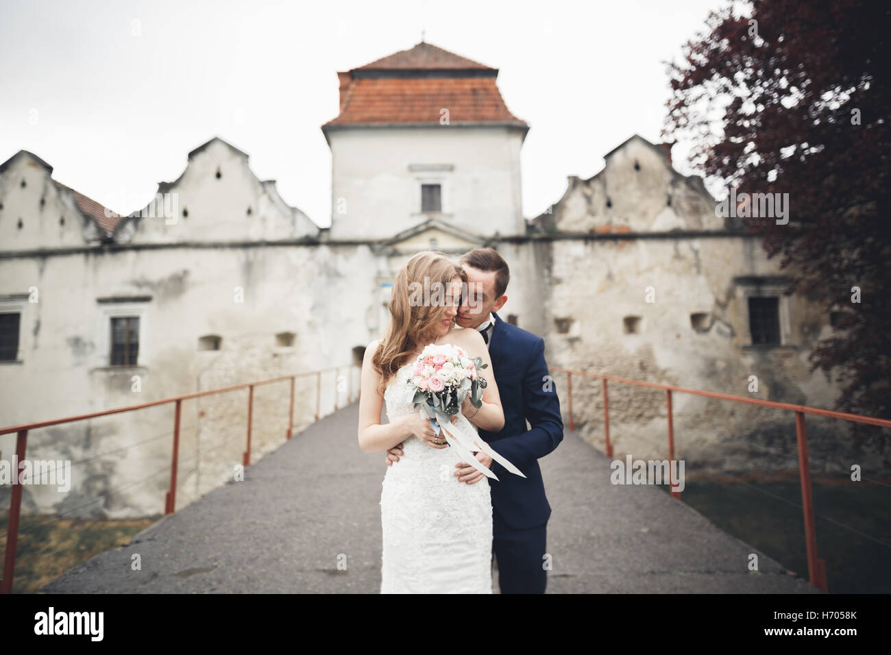Beau mariage romantique couple de jeunes mariés hugging près de Vieux château Banque D'Images