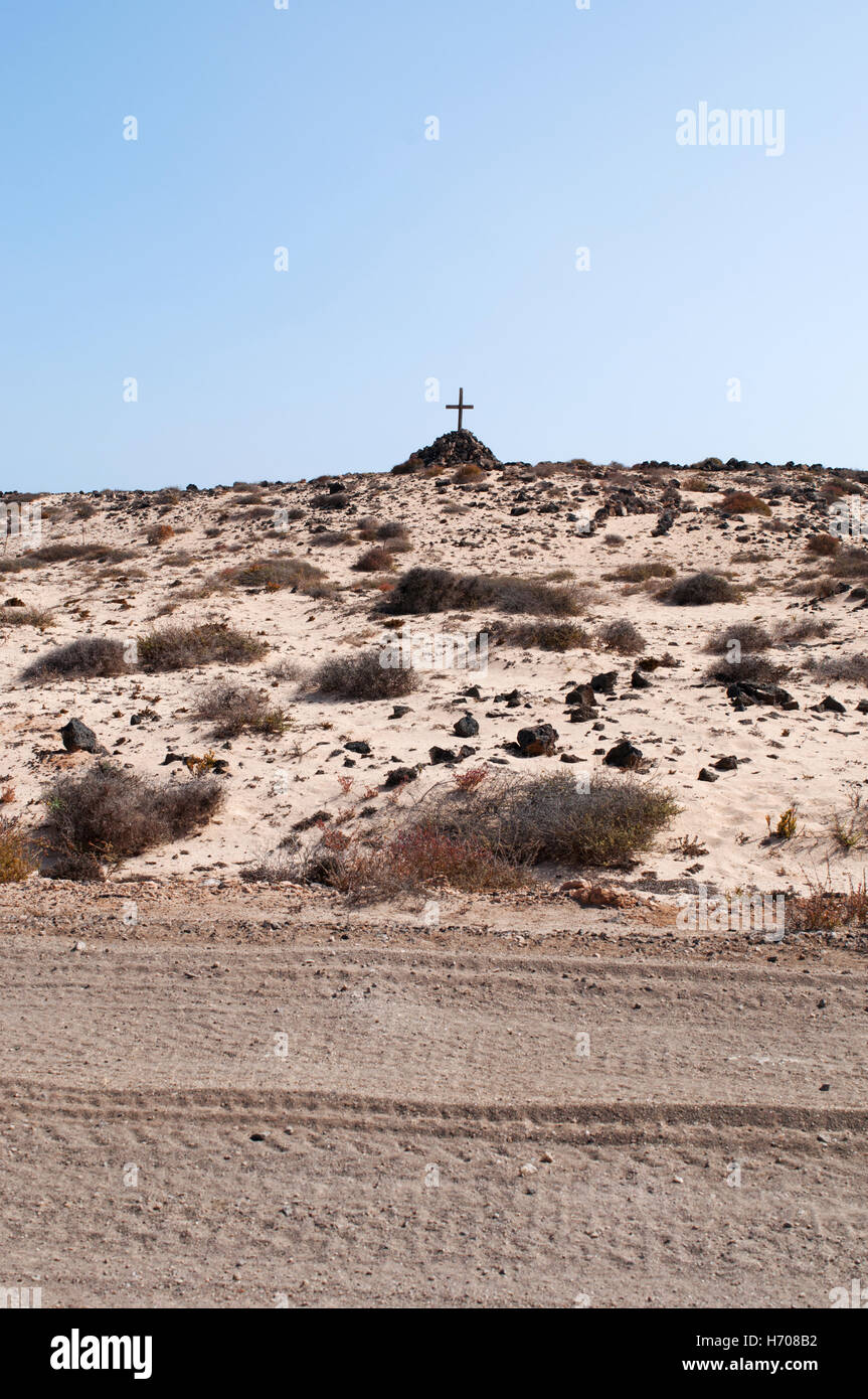 Fuerteventura, Îles Canaries, Afrique du Nord, de l'Espagne : un tombeau avec un tas de pierres et une croix en bois dans le désert près de la ville de El Cotillo Banque D'Images
