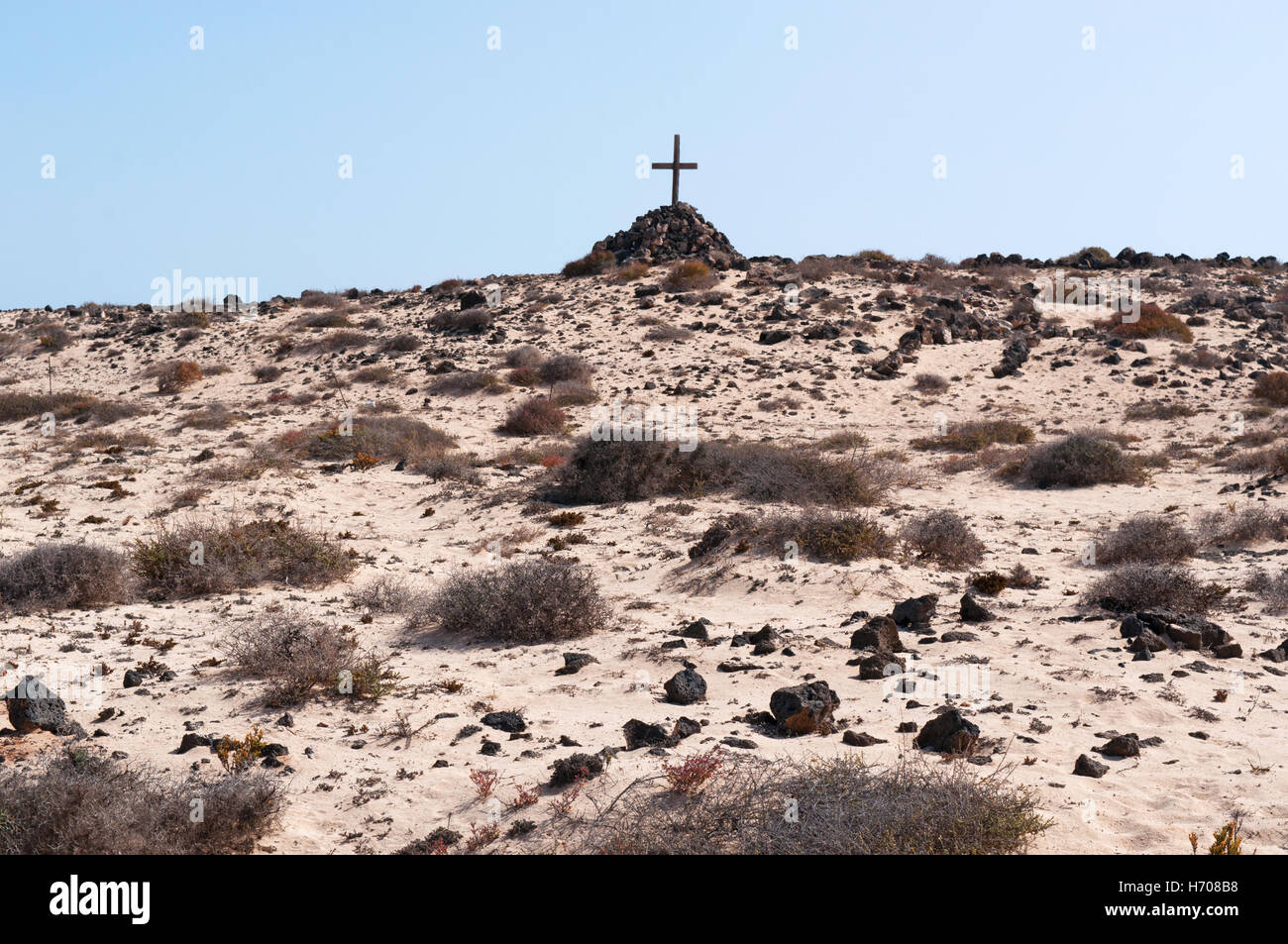 Fuerteventura, Îles Canaries, Afrique du Nord, de l'Espagne : un tombeau avec un tas de pierres et une croix en bois dans le désert près de la ville de El Cotillo Banque D'Images