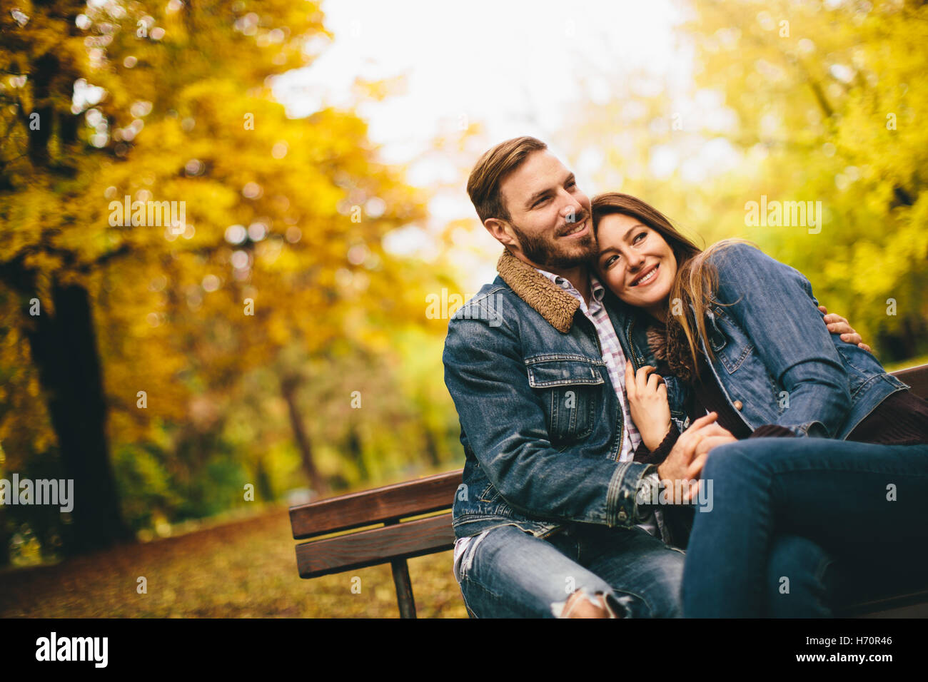 Amour et couple sur un banc dans le parc en automne Banque D'Images