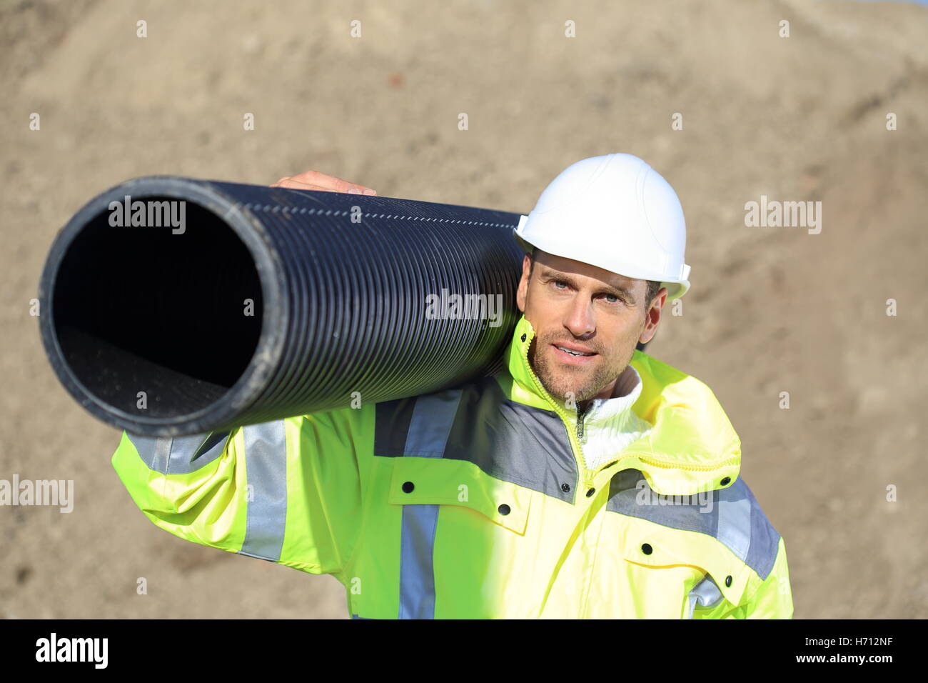 Un travailleur de la Construction avec une pipe sur son épaule Banque D'Images