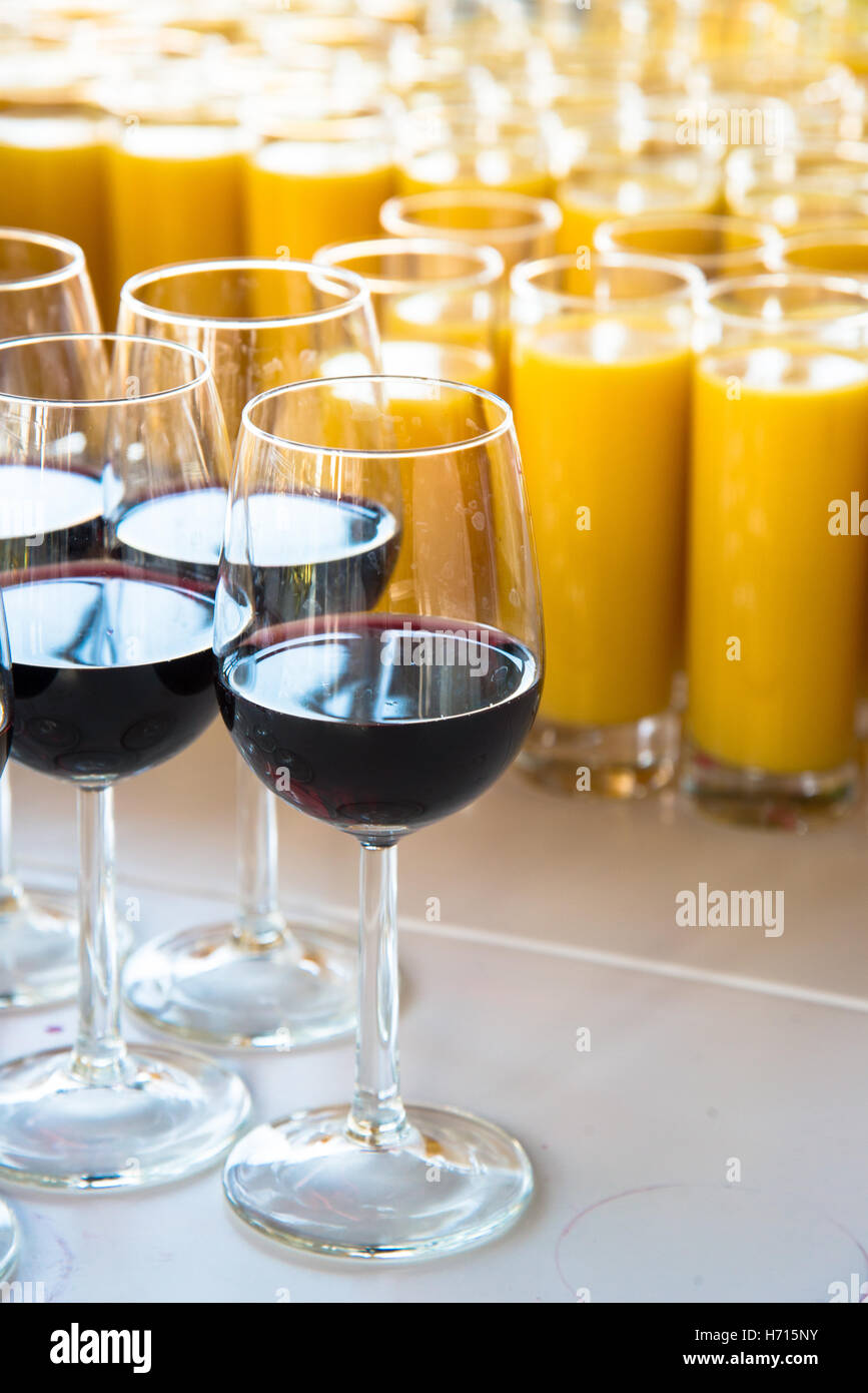 Verres de vin rouge et le jus d'orange à l'attente de l'événement à table Banque D'Images
