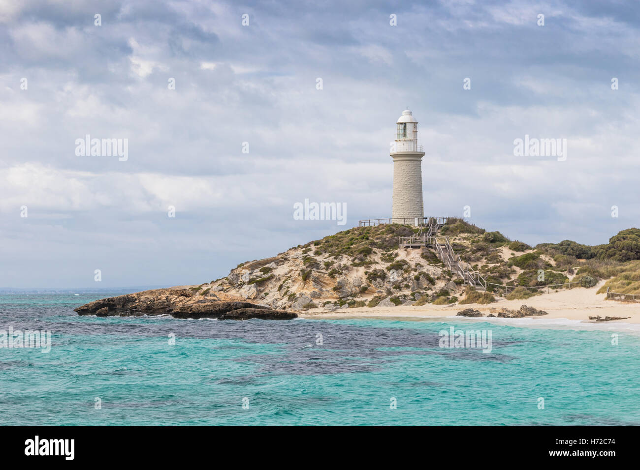 Ciel nuageux sur Pinky Beach et phare de Bathurst à Rottnest Island, près de Perth en Australie occidentale. Banque D'Images