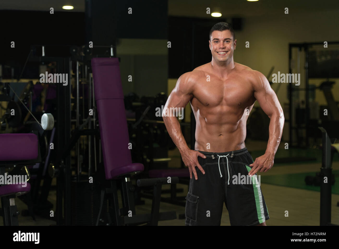 Portrait d'un jeune homme en montrant son corps bien formé - Athletic musculaire Fitness Model Posing Bodybuilder Exercices après Banque D'Images