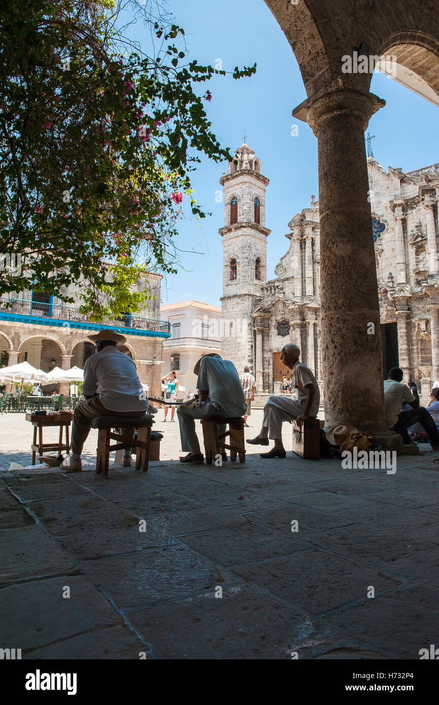 La Havane - Le 11 juin 2011 : Les Cubains profitent de l'ombre dans un portique en entourant la place en face de la Cathédrale de La Havane. Banque D'Images
