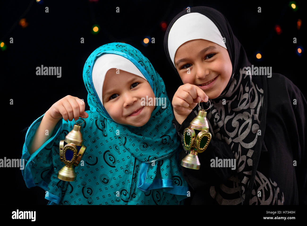 Heureux les filles musulmanes avec lanterne sur le Ramadan nuit lumières fond flou artistique Banque D'Images