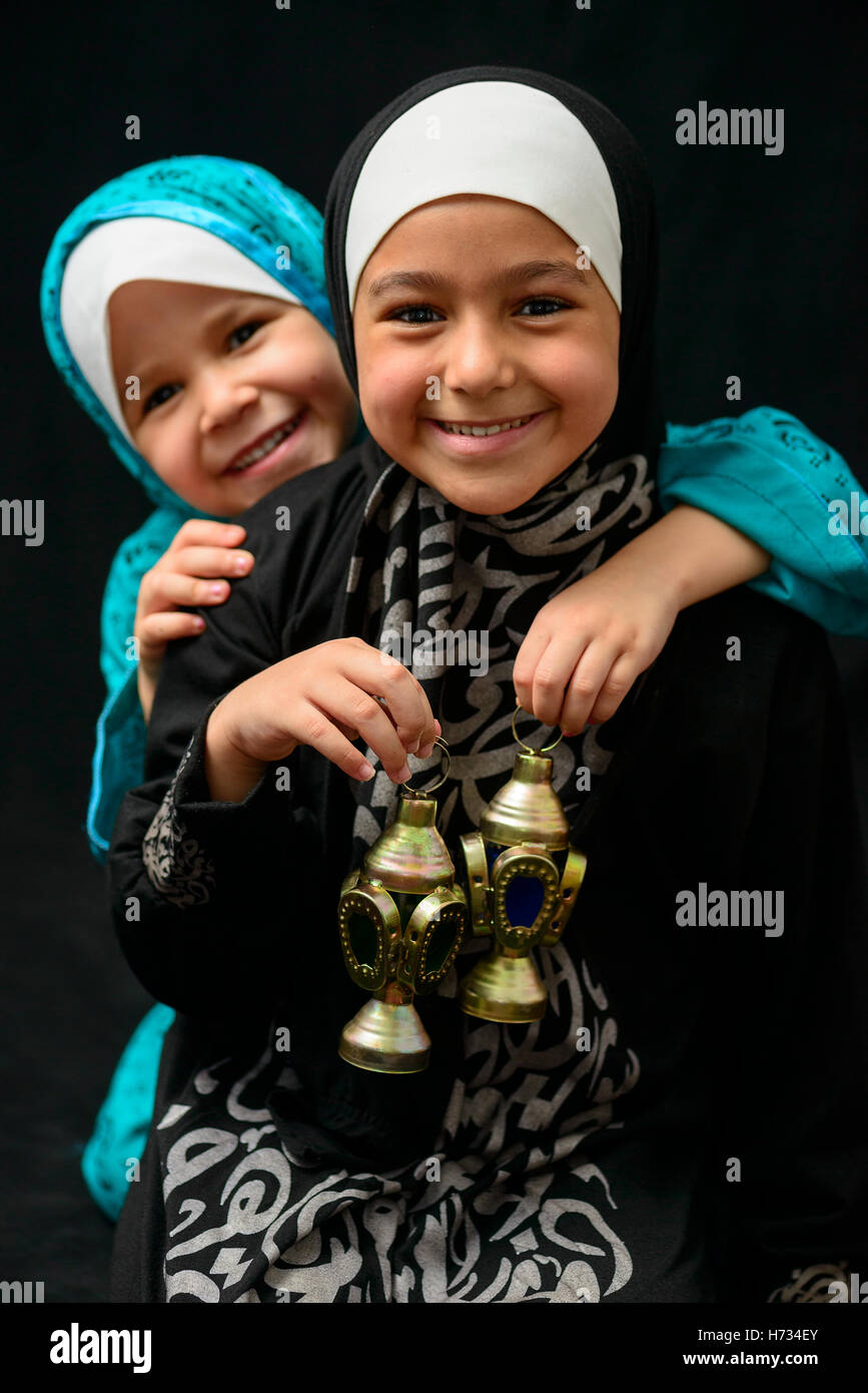 Deux professionnels des filles musulmanes avec Ramadan lanterne sur fond noir Banque D'Images