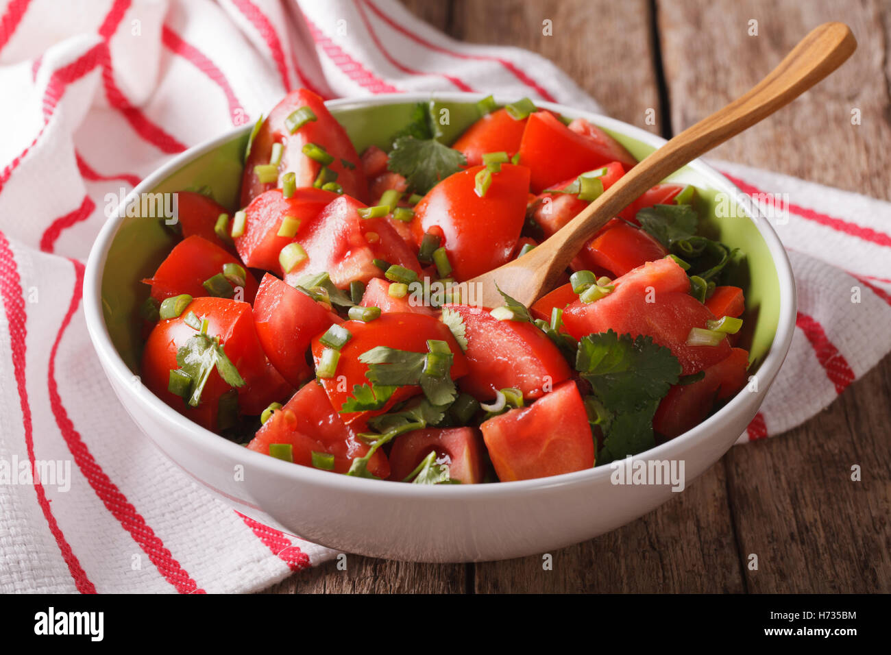 L'alimentation saine : frais salade de tomates avec l'oignon dans un bol sur la table horizontale. Banque D'Images