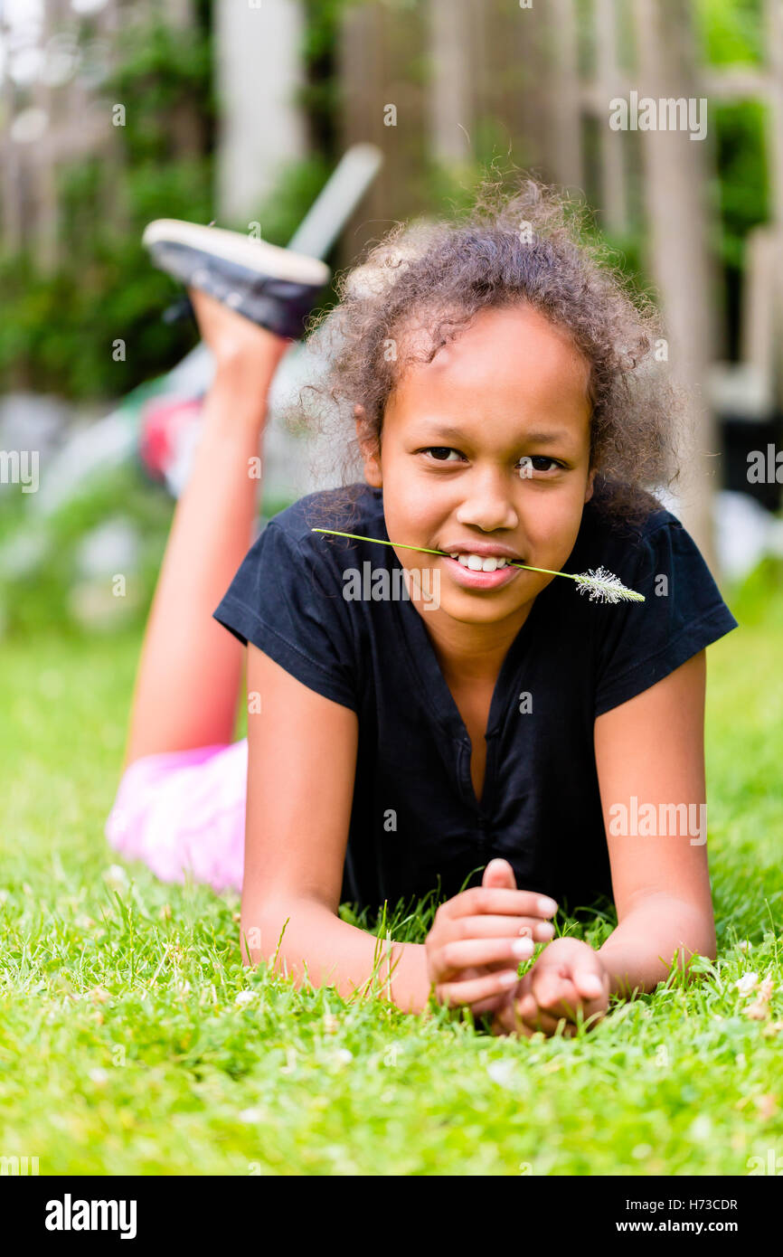 Fille noire avec brin d'herbe est on meadow Banque D'Images