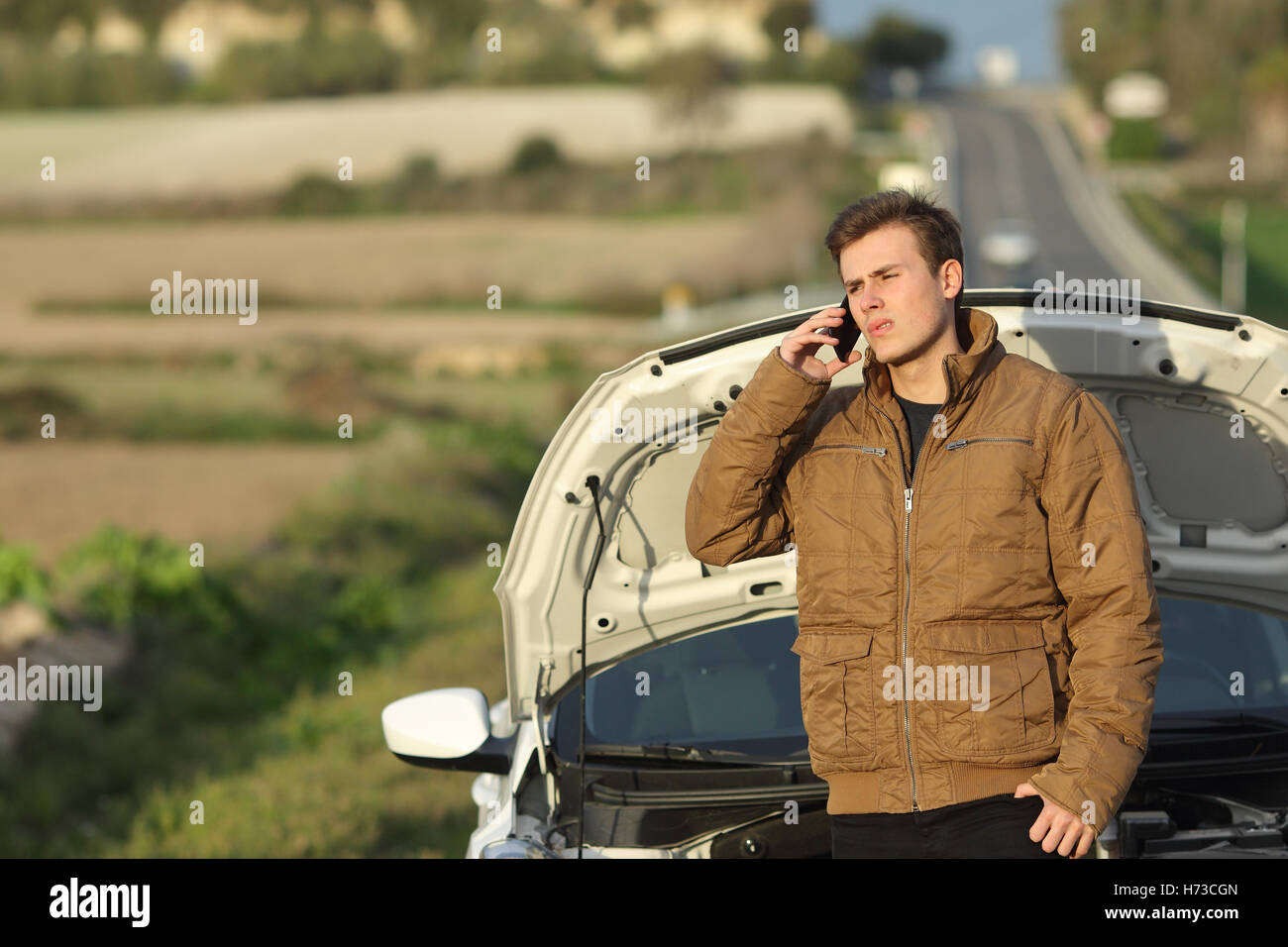 Guy appelant l'assistance routière pour sa voiture panne Banque D'Images