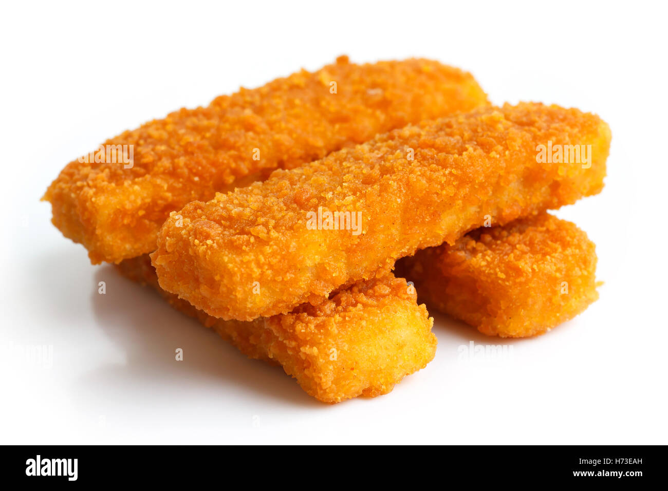 Quatre golden fried fish fingers empilés sur blanc. Banque D'Images