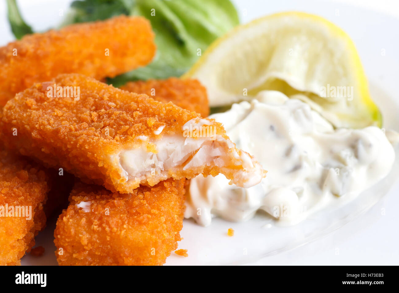 À moitié mangé des bâtonnets de poisson avec du citron et de la sauce  tartare Photo Stock - Alamy