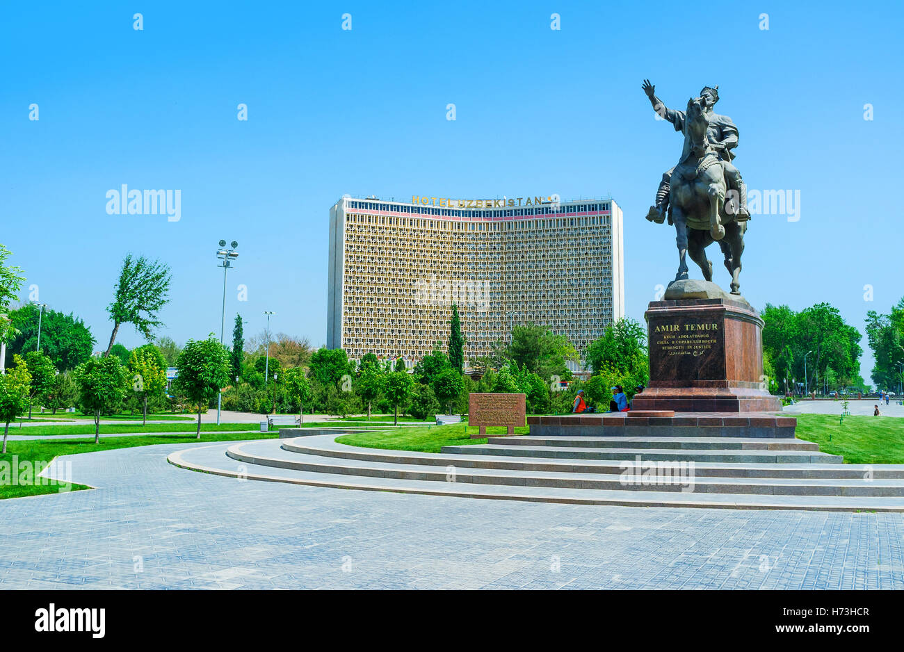 La statue d'Amir Timur, entourée d'un magnifique parc verdoyant et avec l'Hôtel Ouzbékistan en arrière-plan, Tachkent, Ouzbékistan Banque D'Images