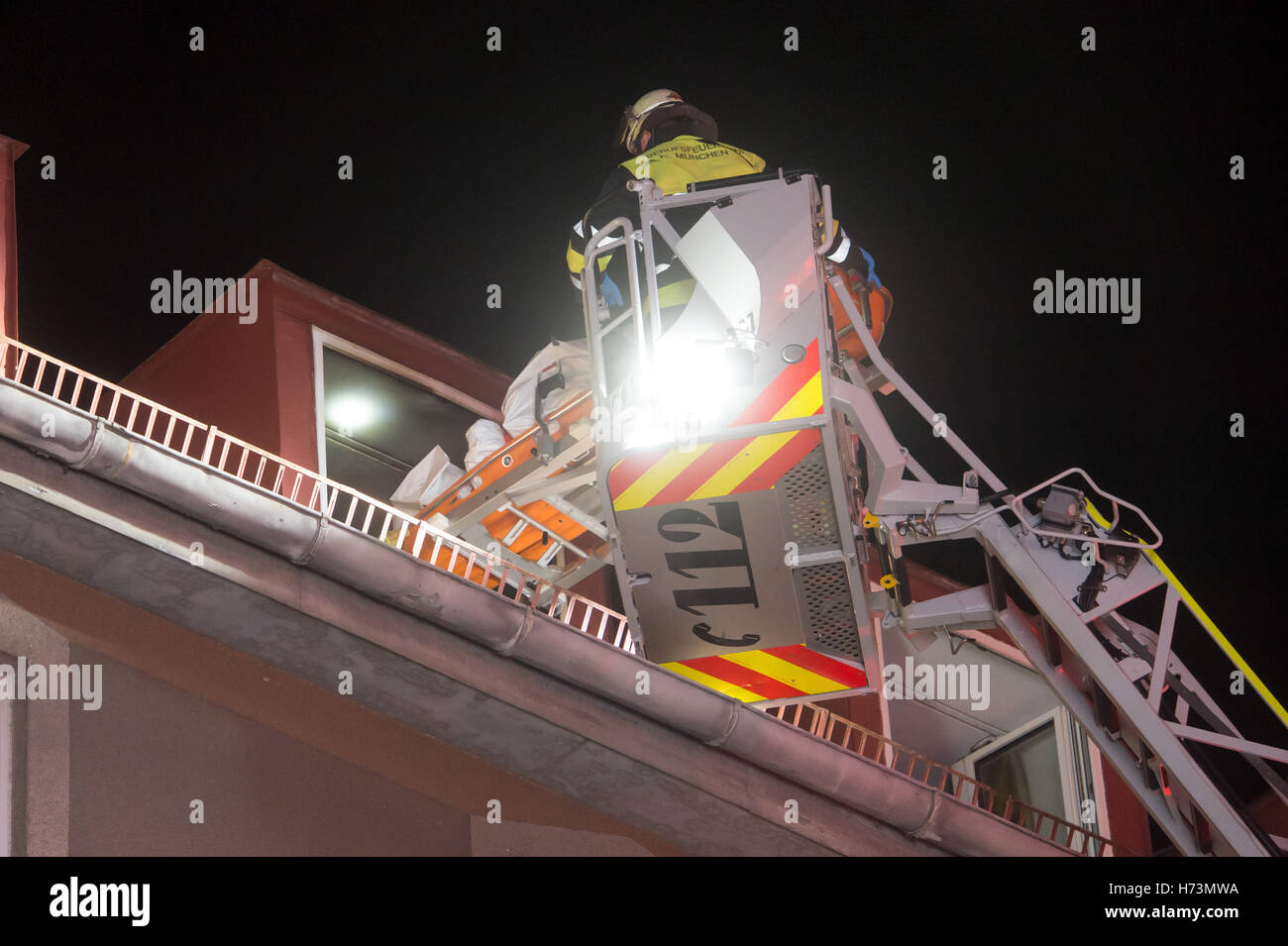 Munich, Allemagne. 09Th Nov, 2016. Un pompier transporte un cadavre sur une civière à partir d'une échelle à un site de déploiement à Munich, Allemagne, 02 novembre 2016. Trois personnes ont été tuées et dix autres habitué dans un feu sur Dachauer-Strasse. Photo : Tobias HASE/dpa/Alamy Live News Banque D'Images