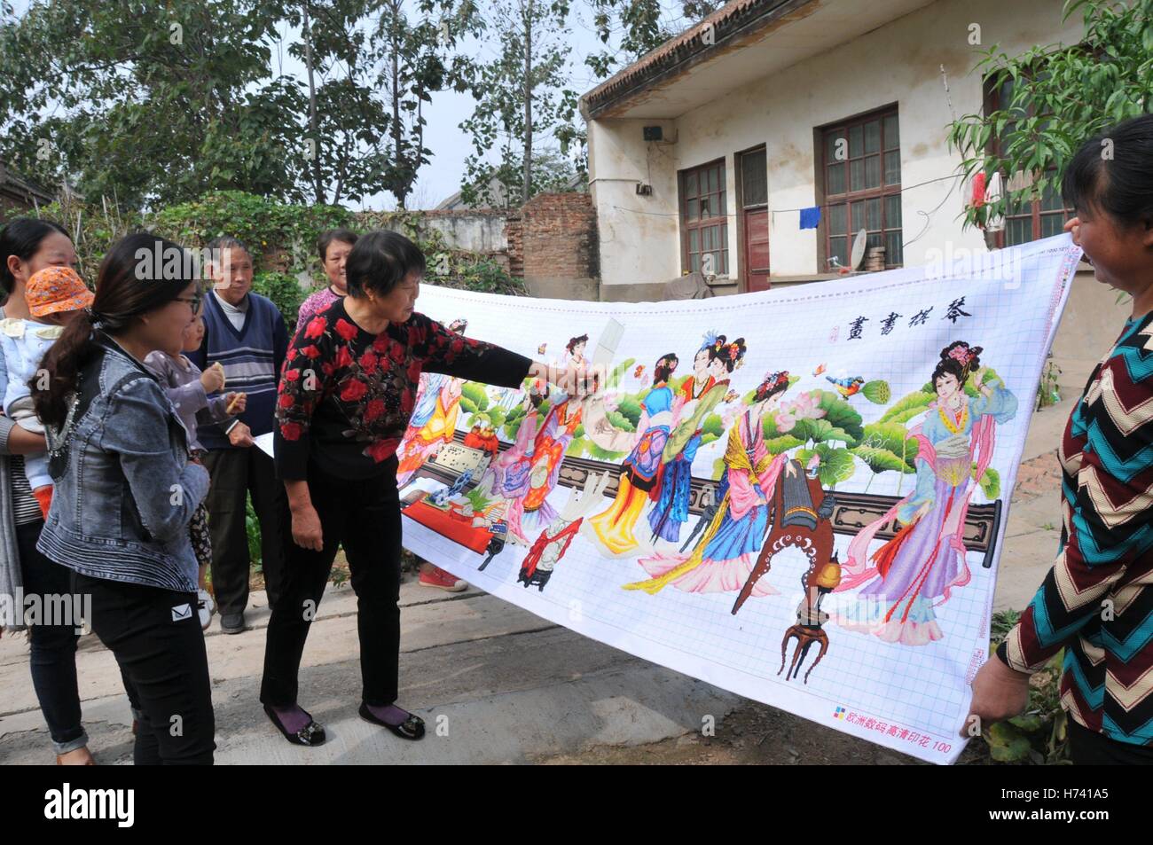 Anyang, Anyang, Chine. 24 Oct, 2016. Anyang, CHINE Le 24 octobre 2016 à : (usage éditorial uniquement. Chine).Il Stéphane Plante, une femme de 71 ans, fait du point de croix à Neihuang County, Ville d'Anyang, province du Henan en Chine centrale, Octobre 24th, 2016. Il Stéphane Plante a commencé à faire du point de croix il y a environ cinq ans. Elle a déjà fait la suture de 'Qingming Riverside Paysage' et d'autres peintures chinoises traditionnelles. La plus grande croix-croix faite par Stéphane Plante Il est à environ 20 mètres de long. Du point de croix est une forme populaire de compte-fil à broder dans lequel X-stitches en forme dans un sol carrelé, raster Banque D'Images