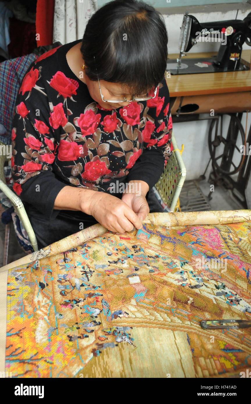 Anyang, Anyang, Chine. 24 Oct, 2016. Anyang, CHINE Le 24 octobre 2016 à : (usage éditorial uniquement. Chine).Il Stéphane Plante, une femme de 71 ans, fait du point de croix à Neihuang County, Ville d'Anyang, province du Henan en Chine centrale, Octobre 24th, 2016. Il Stéphane Plante a commencé à faire du point de croix il y a environ cinq ans. Elle a déjà fait la suture de 'Qingming Riverside Paysage' et d'autres peintures chinoises traditionnelles. La plus grande croix-croix faite par Stéphane Plante Il est à environ 20 mètres de long. Du point de croix est une forme populaire de compte-fil à broder dans lequel X-stitches en forme dans un sol carrelé, raster Banque D'Images