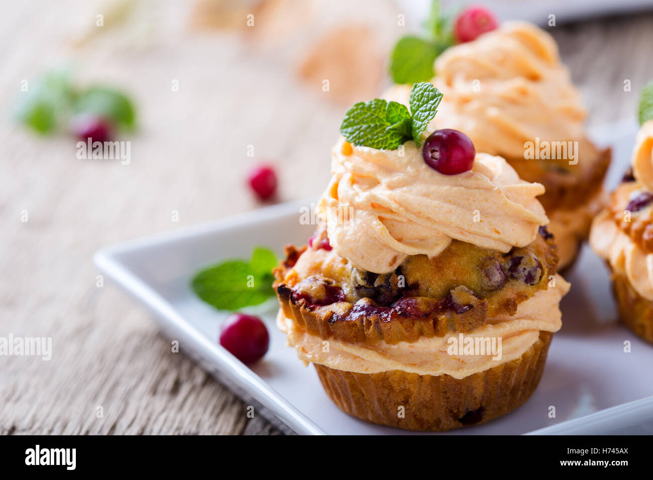 Automne citrouille canneberges maison cupcakes avec glaçage au fromage à la crème sur la table en bois rustique Banque D'Images