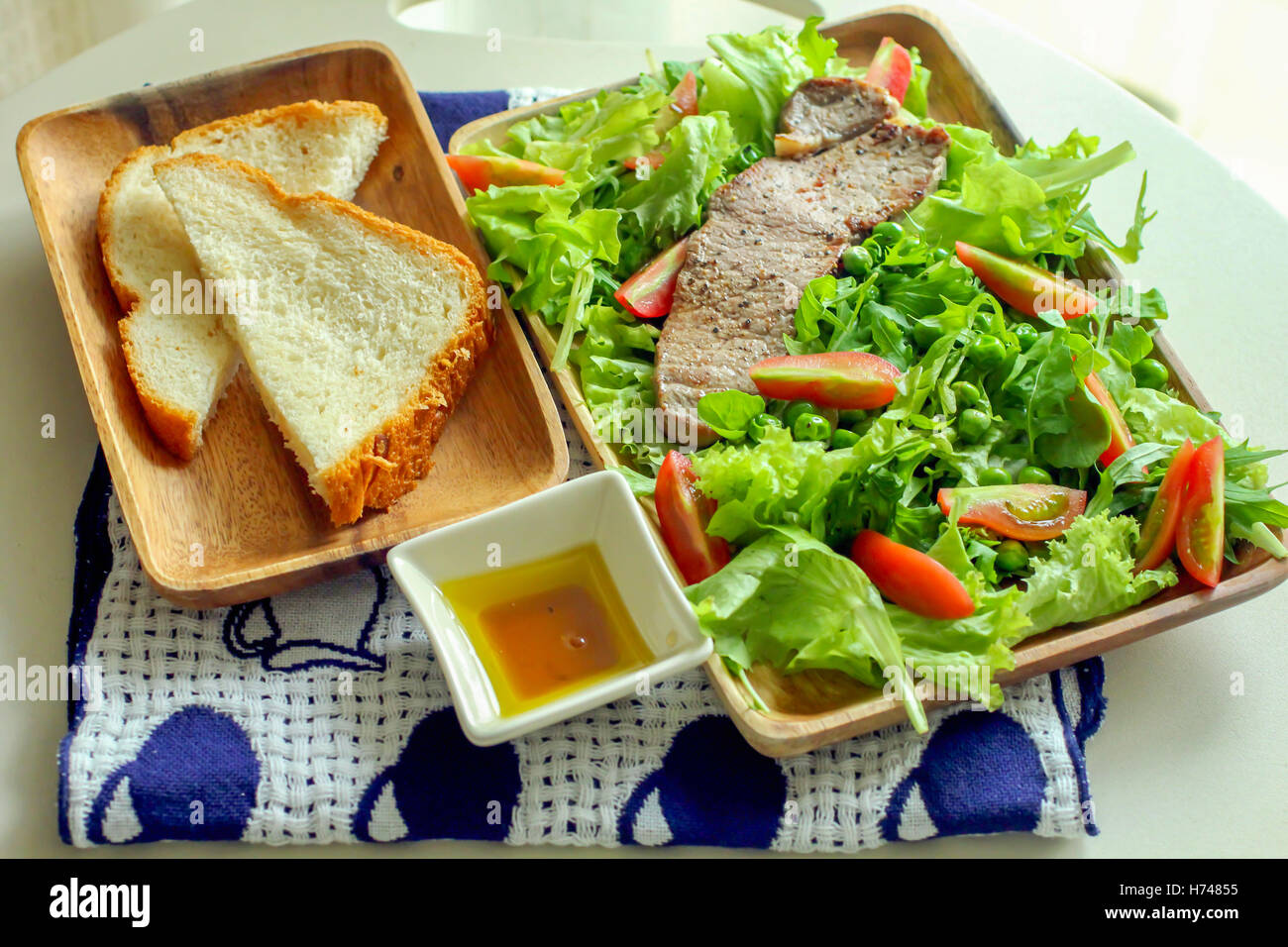 Les steaks grillés et salade de légumes et le pain coupé en tranches. Banque D'Images