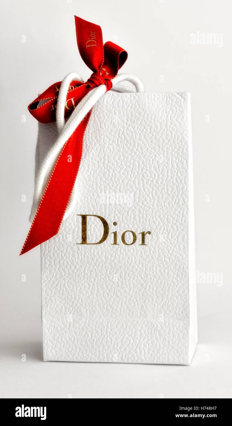 Un sac cadeau blanc dior avec un archet rouge attaché Photo Stock - Alamy