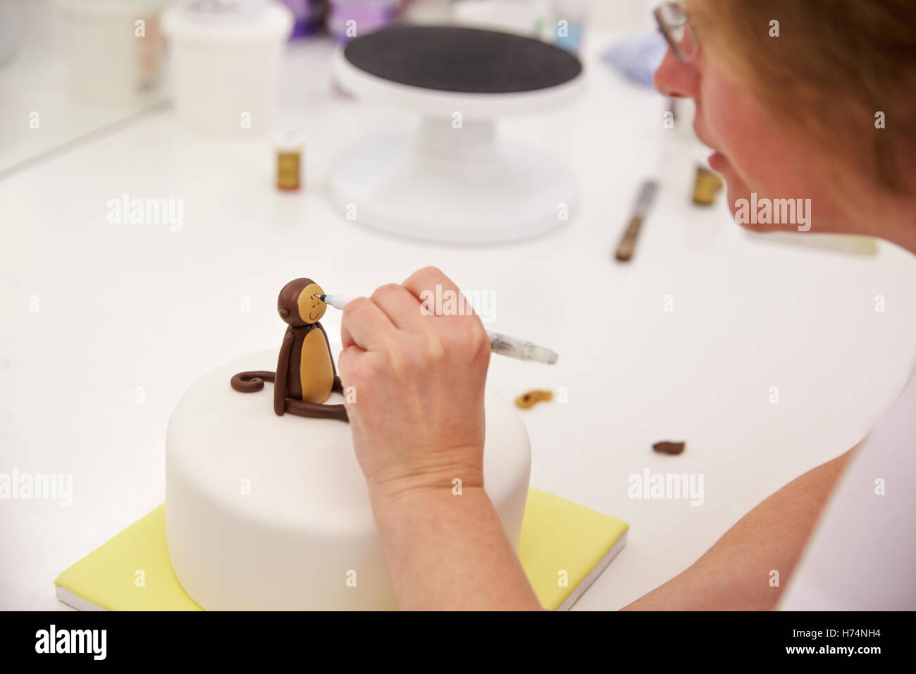 Close Up of Woman in Bakery faisant Monkey Cake Decoration Banque D'Images