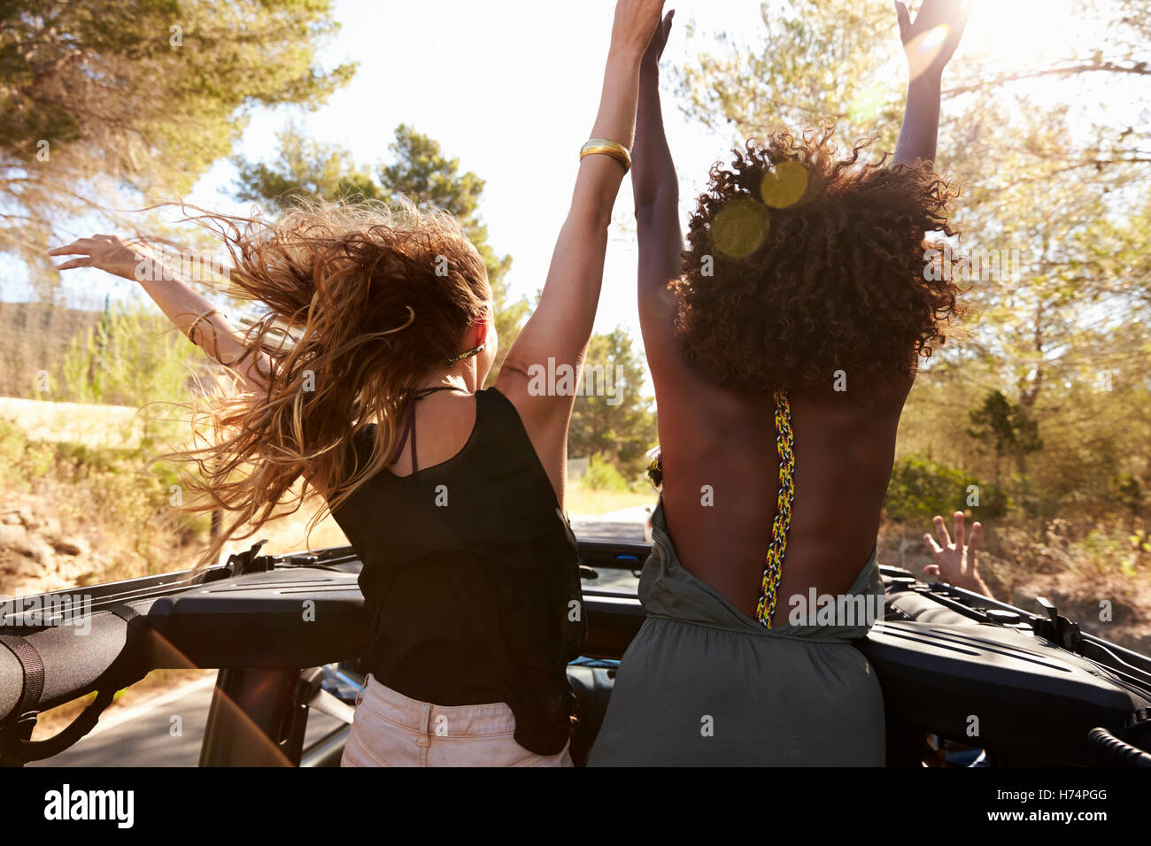 Les femmes sont deux excités à l'arrière de voiture ouverte, vue arrière Banque D'Images
